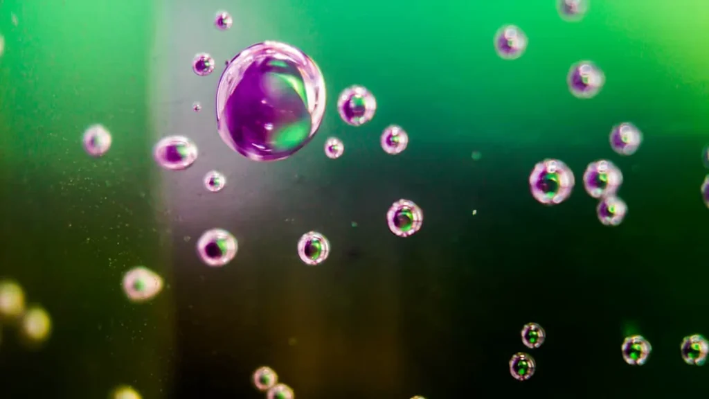Bolhas iridescentes sobre fundo verde e magenta